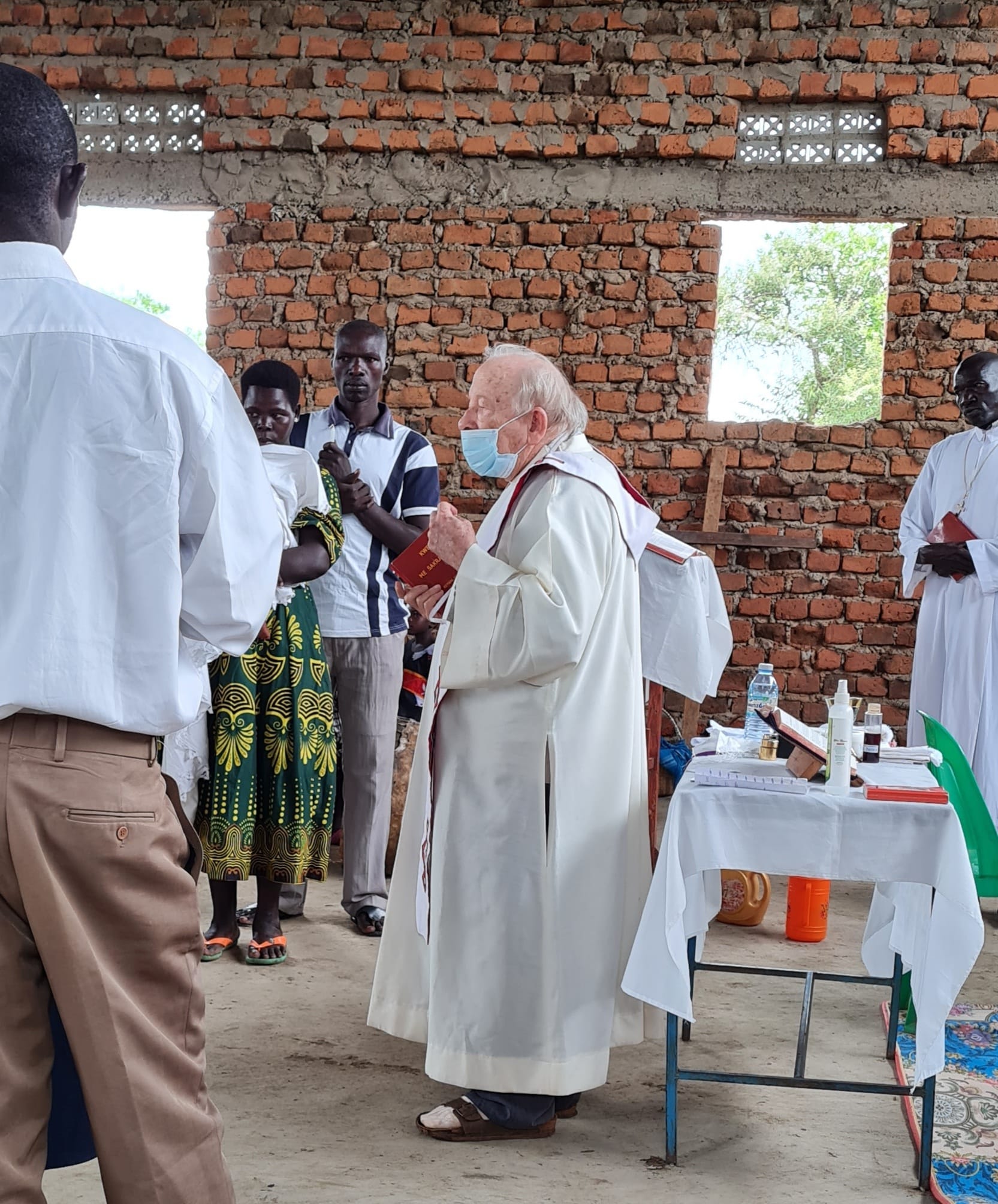 Father Alberto Anichini celebrates Mass at one of the outposts in his parish. The church is open air, with brick walls. 